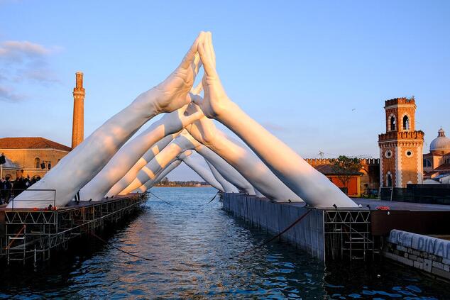 The sculpture "Building Bridges" in the city of Venice. Lorenzo Quinn sculpture Venice