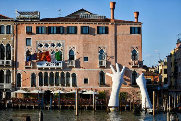 Lorenzo Quinn's hands hold the façade of the Ca s'Agredo hotel in Venice. Lorenzo Quinn sculpture Venice