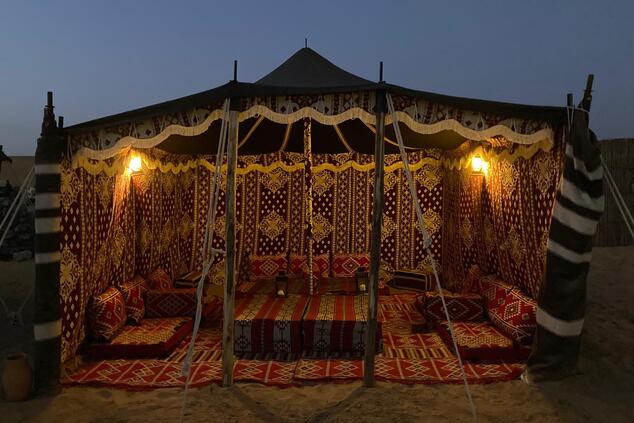 Typical Bedouin tents, decorated with rugs and embroidered fabrics. bedouin desert dining experience Dubai